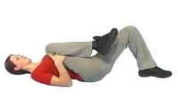 Person lying on their back with one knee bent and foot on the floor. The other knee is lifted towards their chest with their hands placed behind the knee.